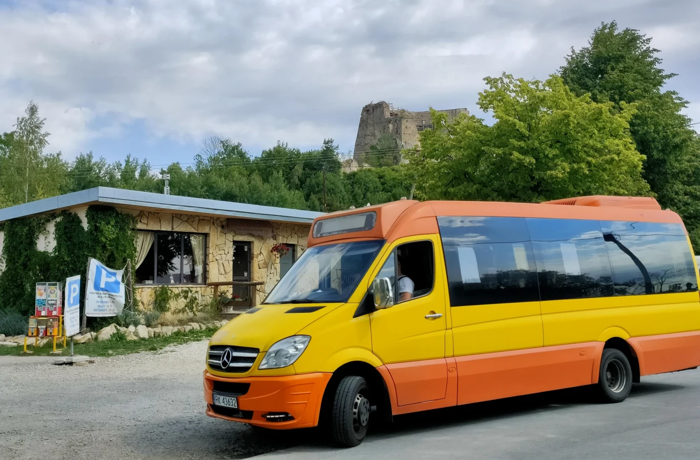 Krośnieński autobus pozuje przed zamkiem. W tle widoczny wjazd na parking