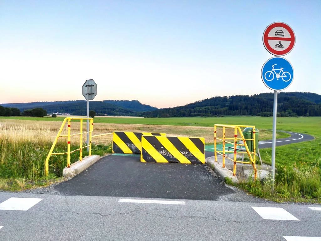 Skrzyżowanie drogi rowerowej z jezdnią zabezpieczone betonowym zaporami