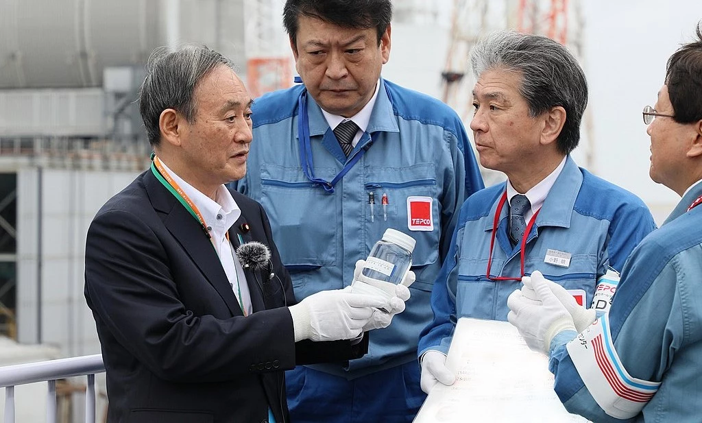 Premier Japonii z próbką zanieczyszczonej wody