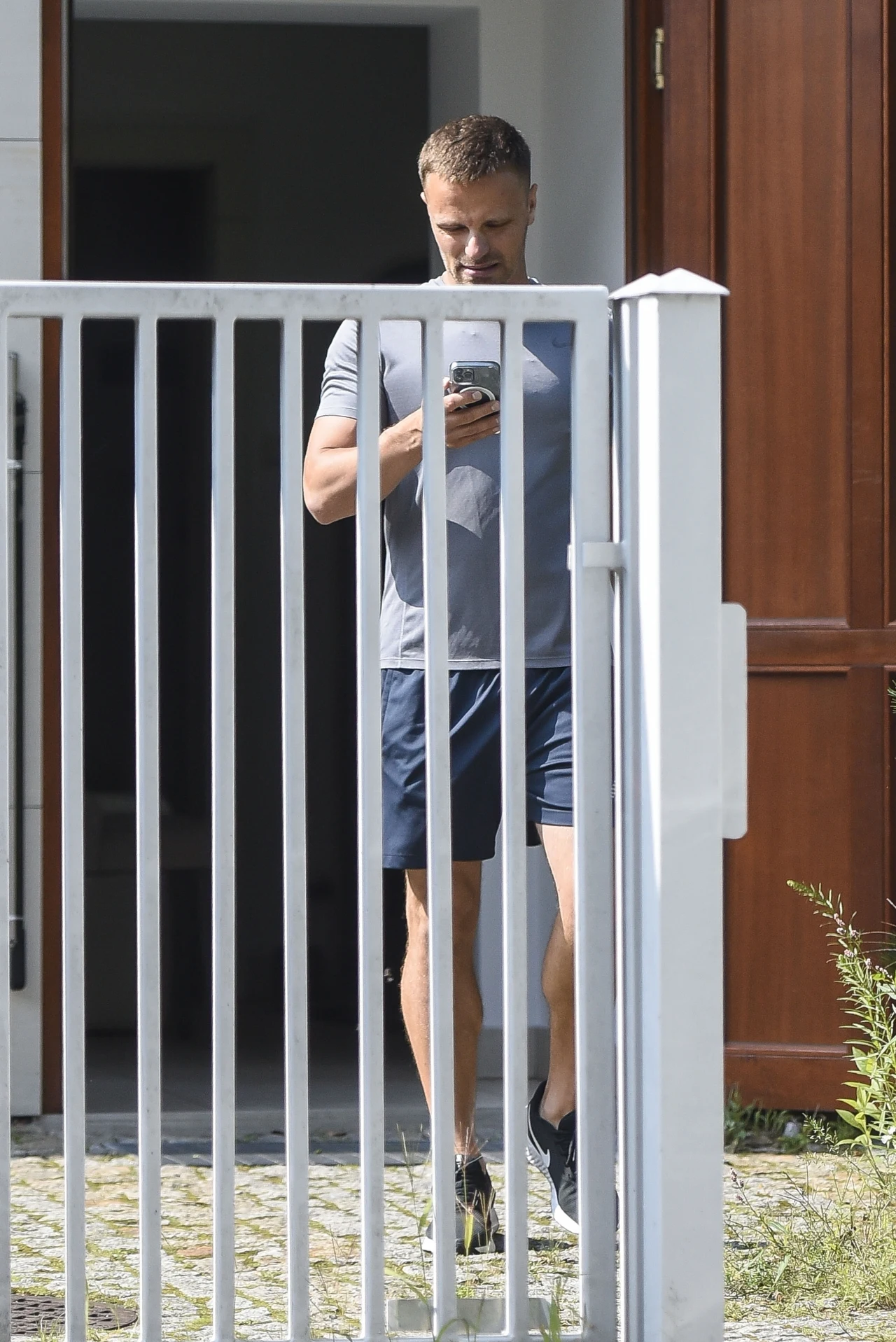 Marcin Hakiel wychodzi z siłowni. Jego wzrok cały czas jest skupiony na telefonie