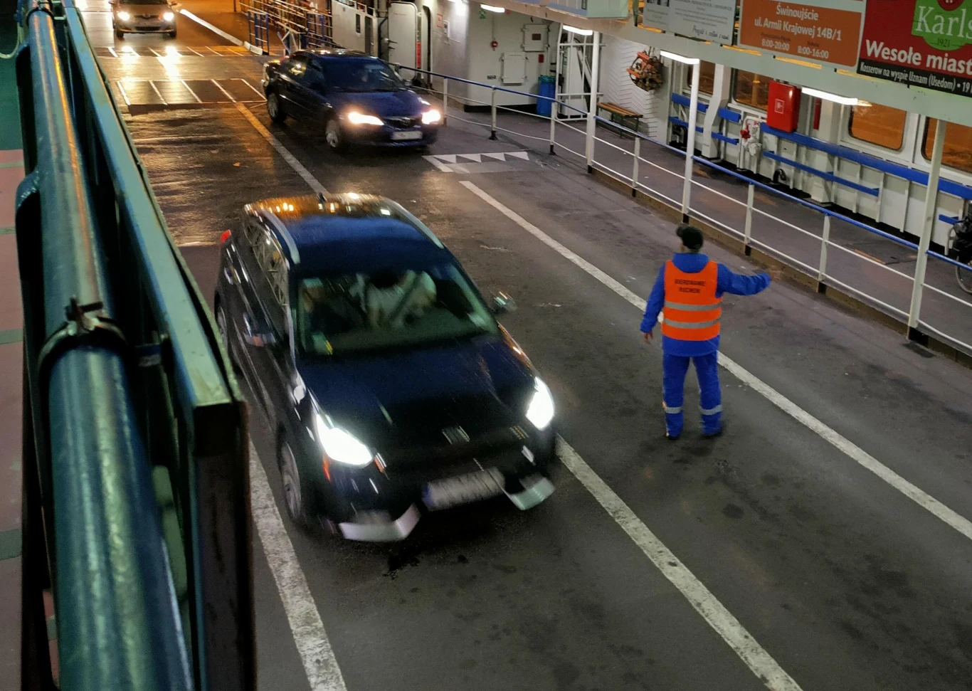 Pracownik Żeglugi Świnoujskiej ustawiający samochody na promie Pracownik Żeglugi Świnoujskiej ustawiający samochody na promie