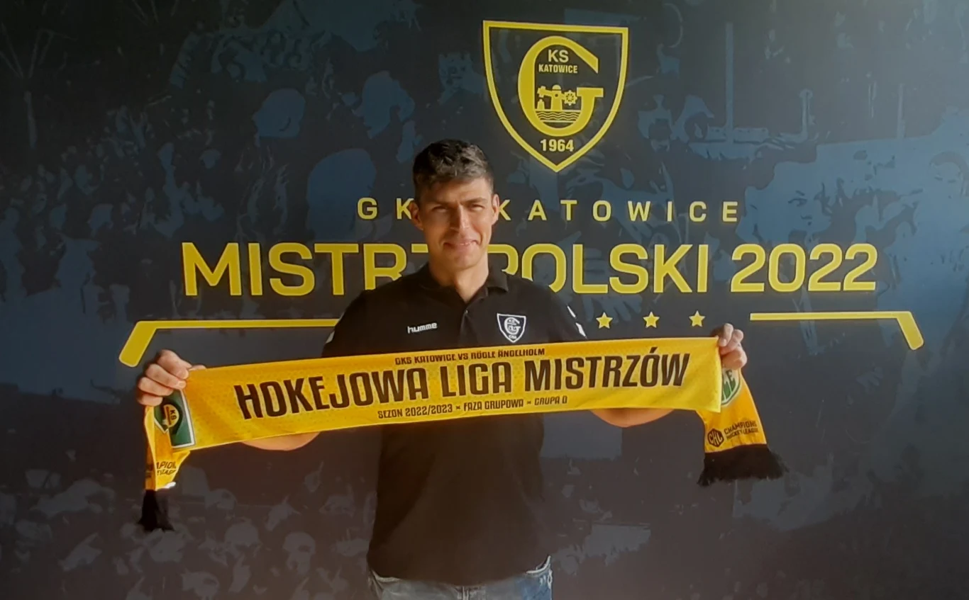 Grzegorz Pasiut z GKS-u Katowice prezentuje klubowy szalik na hokejową Ligę Mistrzów