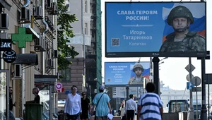 Moskwa; Rosjanie przechodzą obok billboardów z rosyjskimi żołnierzami i hasłem "Chwała bohaterom Rosji"