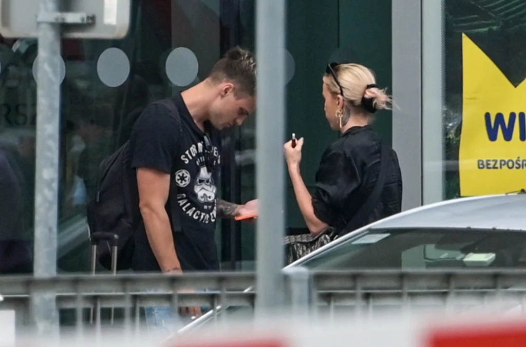 W oczekiwaniu na taksówkę przystanęli przed wejściem na lotnisko W oczekiwaniu na taksówkę przystanęli przed wejściem na lotnisko