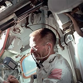 Astronauta Walter Cunningham, pilot modułu księżycowego Apollo 7, robi notatki kosmicznym długopisem podczas dziewiątego dnia misji.