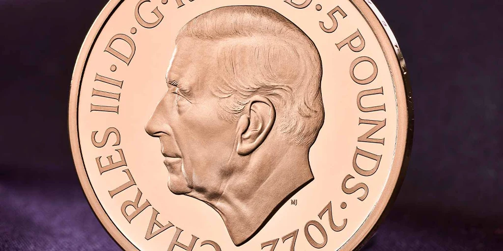 Na inskrypcji oznaczono poprzednich brytyjskich monarchów za pomocą łacińskiej wersji ich imienia.  Pełny napis otaczający wizerunek Karola III brzmi: "CHARLES III • D • G • REX • F • D • 5 POUNDS • 2022", co oznacza "Król Karol III, z łaski Bożej, Obrońca Wiary".  Fot. The Royal Mint 