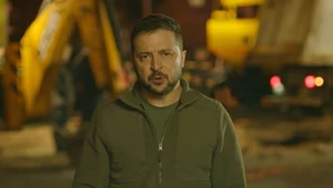 Prezydent Wołodymyr Zełenski w trakcie przemówienia na tle zniszczonego Kijowa
