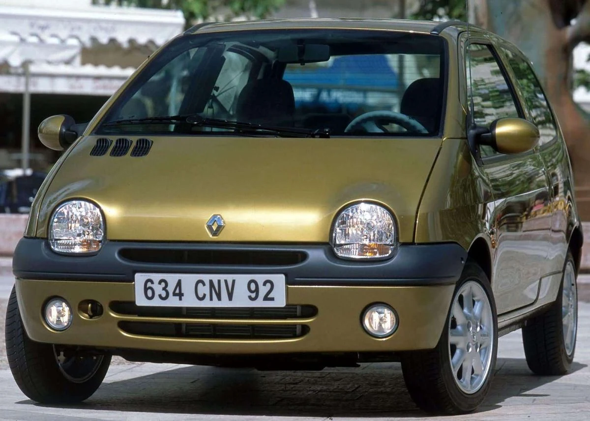 Renault Twingo. Samochód zaprezentowano w 1992 roku na salonie w Paryżu. Pierwsze egzemplarze trafiły do nabywców w 1993 roku. Auto wyróżniało się m.in jednobryłowym nadwoziem i nietypowym, minimalistycznym, projektem wnętrza. Ten objawiał się chociażby brakiem klasycznych zegarów i nowatorskimi - jak na pierwszą połowę lat dziewięćdziesiątych - &quot;smaczkami&quot; pokroju jaskrawych pokręteł i przełączników. 