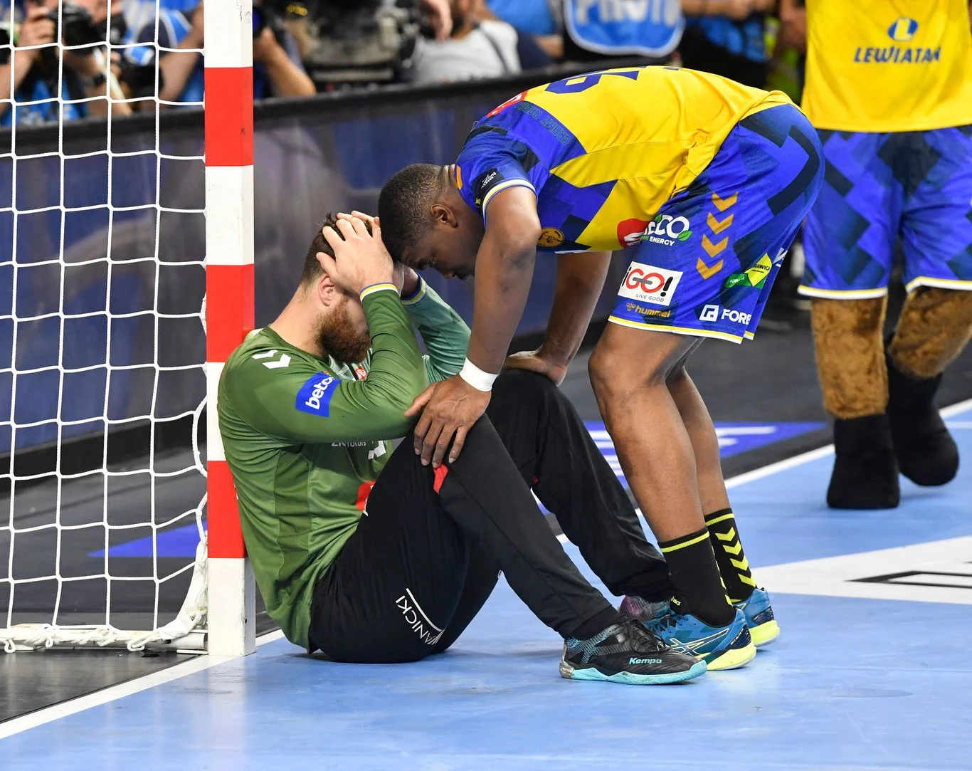 Andreas Wolff pocieszany przez Dylana Nahiego po przegranym w rzutach karnych finale Ligi Mistrzów z Barceloną