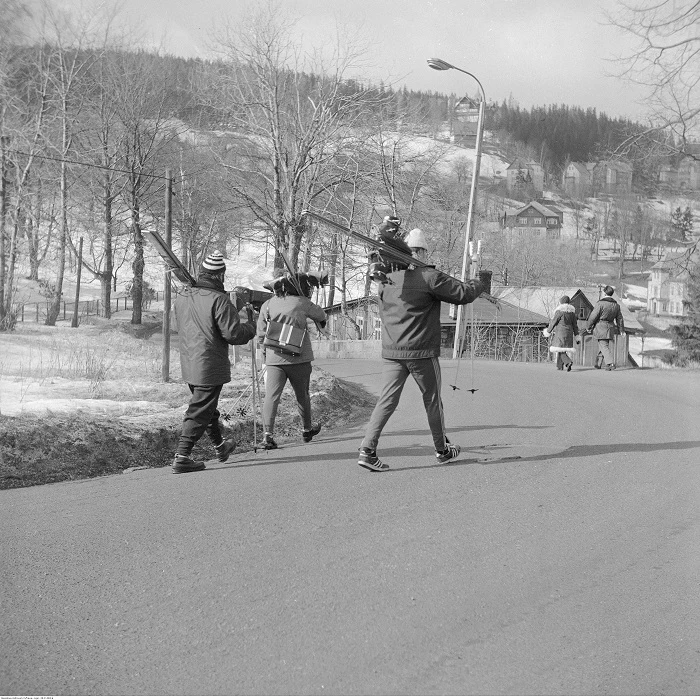 Narciarze niosący narty na zakręcie górskiej drogi (Bierutowice, Karpacz)