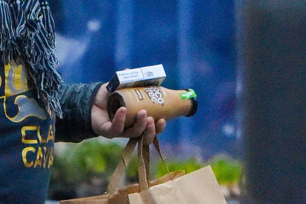 Bartosz Żukowski wychodzi ze sklepu niosąc ze sobą podręczne zakupy Bartosz Żukowski wychodzi ze sklepu niosąc ze sobą podręczne zakupy