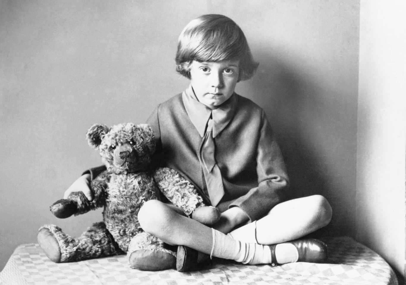 Christopher Robin Milne, czyli pierwowzór książkowego Krzysia wraz ze swoim misiem Winnie-the-Pooh, którego w Polsce znamy jako Kubuś Puchatek. Pierwszy człon imienia pluszaka był zapożyczeniem od imienia niedźwiedzicy Winnipeg, która trafiła do zoo w Londynie z Kanady