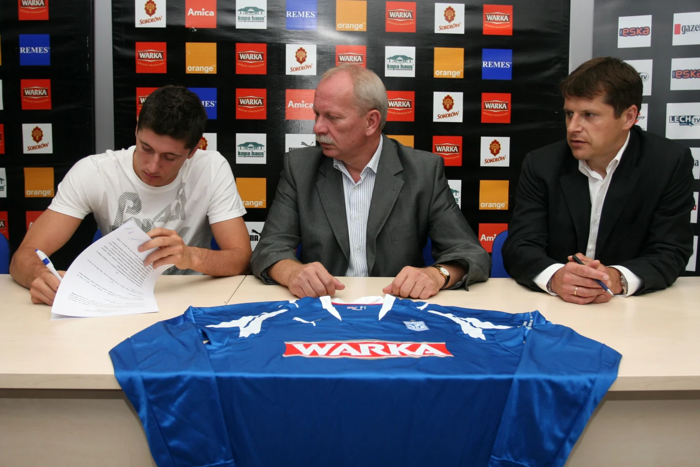 Robert Lewandowski podczas podpisywania kontraktu z Lechem Poznań - obok ówczesny dyrektor Marek Pogorzelczyk i menedżer Cezary Kucharski