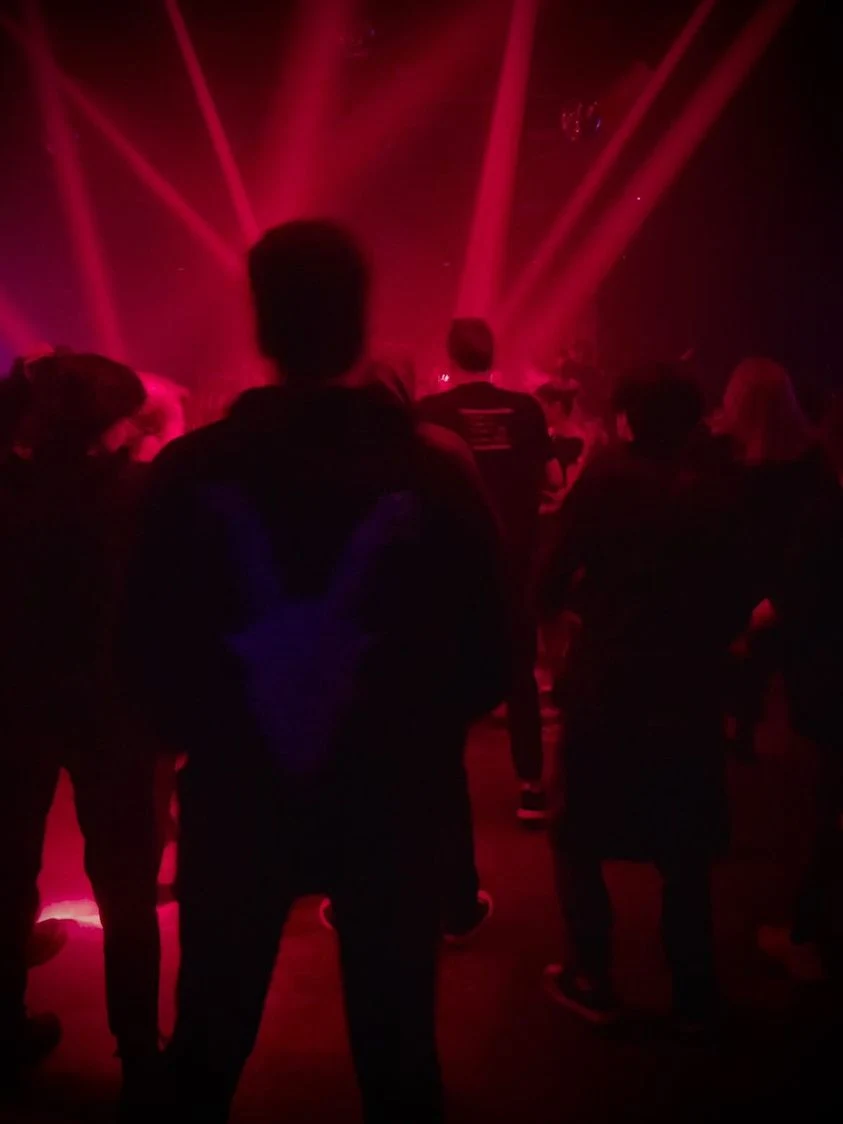 Czerwone lasery oświetlają scenę z DJ-em