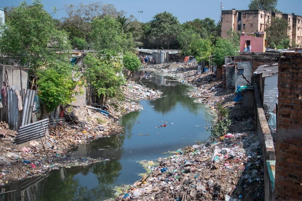 Rzeka wypełniona odpadami z tworzyw sztucznych w indyjskich slumsach