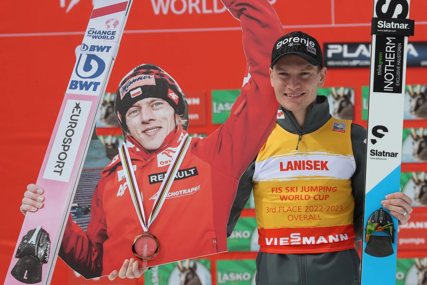 Anze Lanisek z tekturową postacią Dawida Kubackiego na podium klasyfikacji generalnej PŚ w skokach narciarskich Anze Lanisek z tekturową postacią Dawida Kubackiego na podium klasyfikacji generalnej PŚ w skokach narciarskich