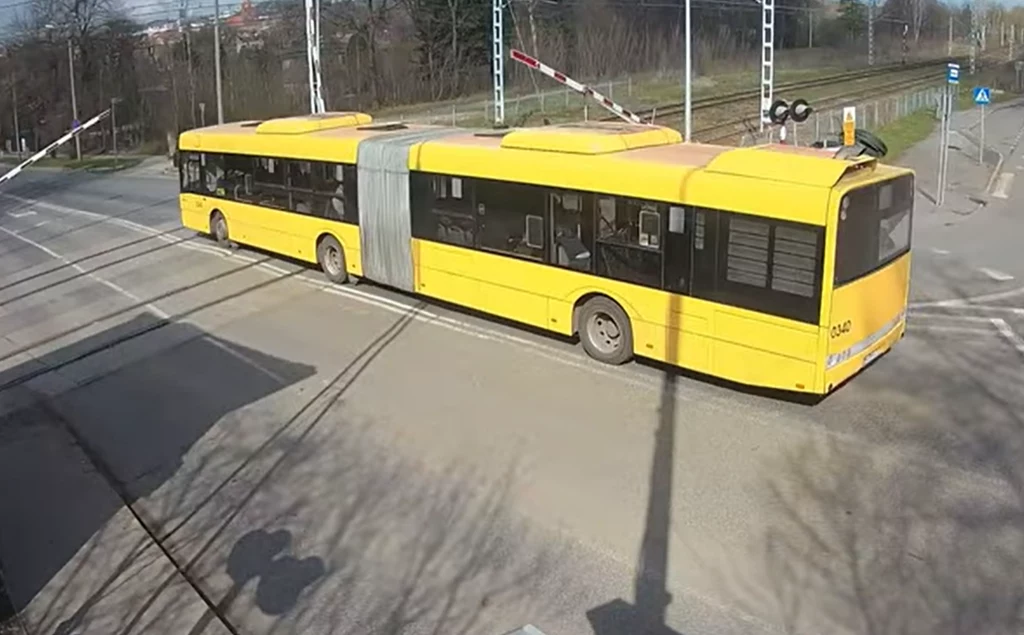 Kierowca autobusu zignorował czerwone światła oraz opuszczające się zapory i przejechał przez tory kolejowe.