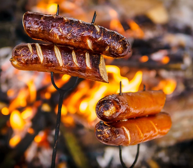 Upieczona kiełbasa nadziana na kij do ogniska 