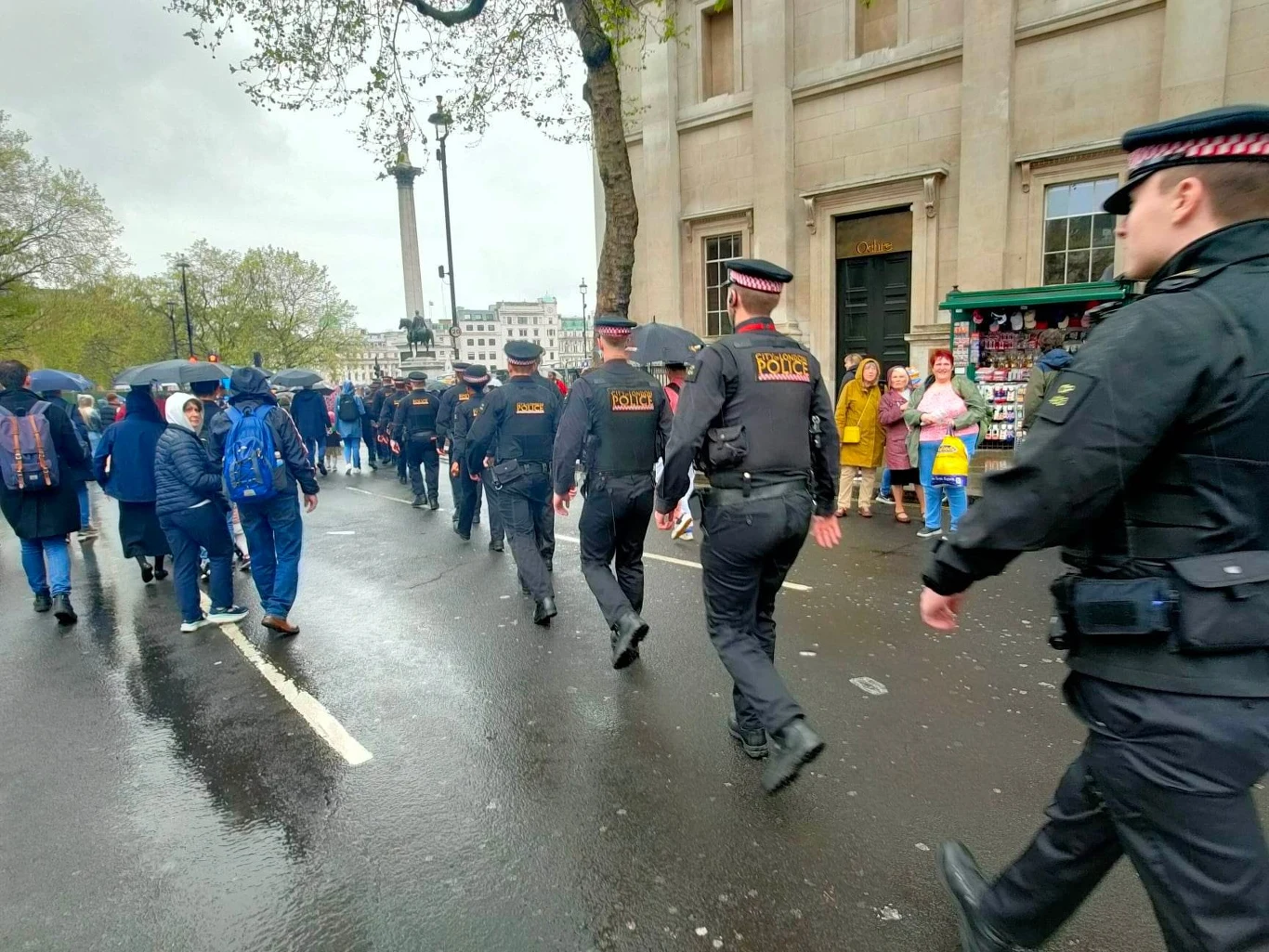Kolumna policjantów sunąca w strugach deszczu w kierunku Trafalgar Square Kolumna policjantów sunąca w strugach deszczu w kierunku Trafalgar Square