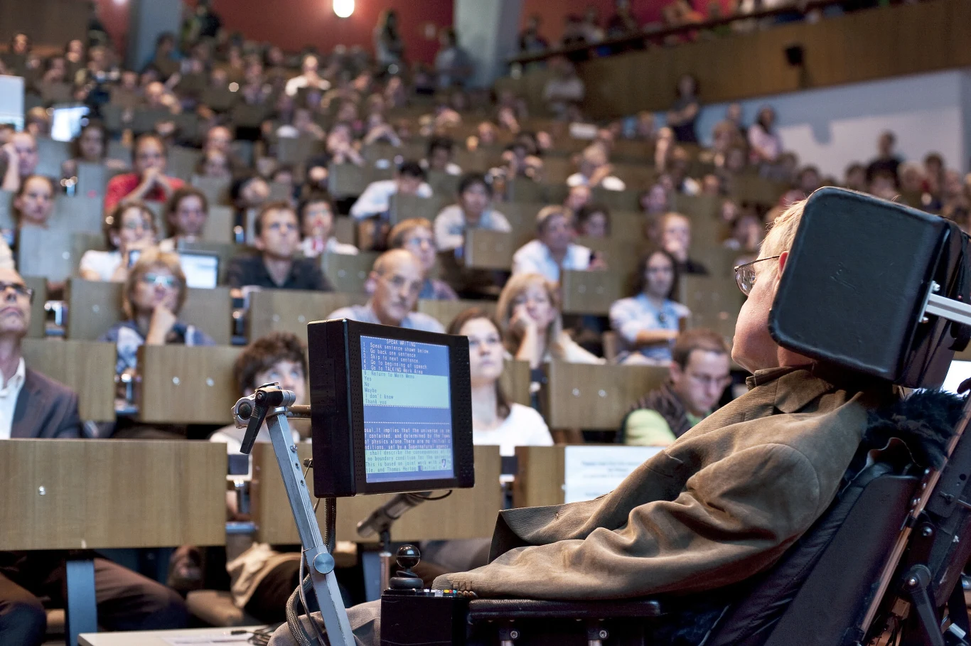 Stephen Hawking prowadził wykłady za pomocą specjalnego syntezatora mowy, który był przymocowany do wózka inwalidzkiego Stephen Hawking prowadził wykłady za pomocą specjalnego syntezatora mowy, który był przymocowany do wózka inwalidzkiego