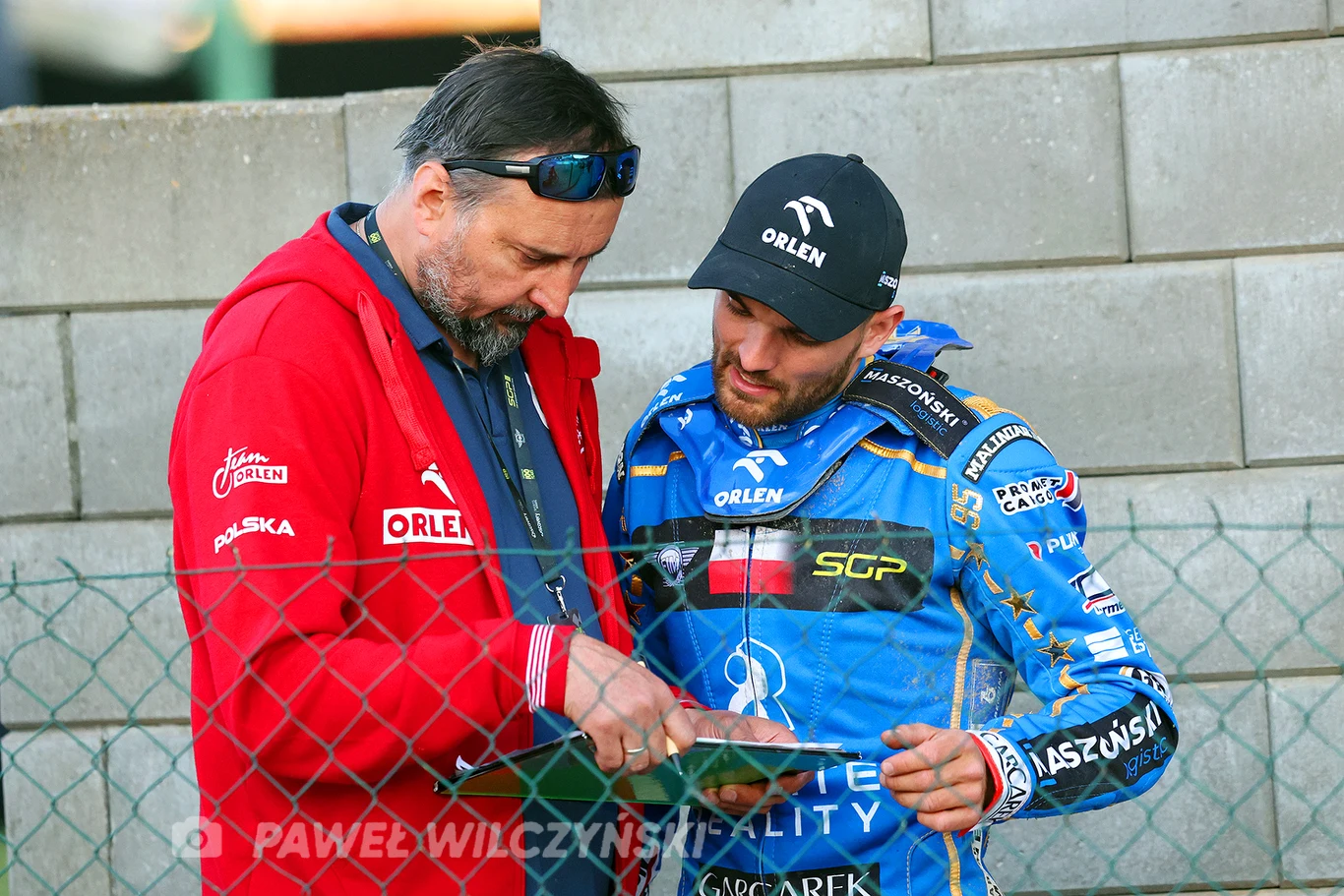 Bartosz Zmarzlik i szybka konsultacja z trenerem kadry Rafałem Dobruckim.