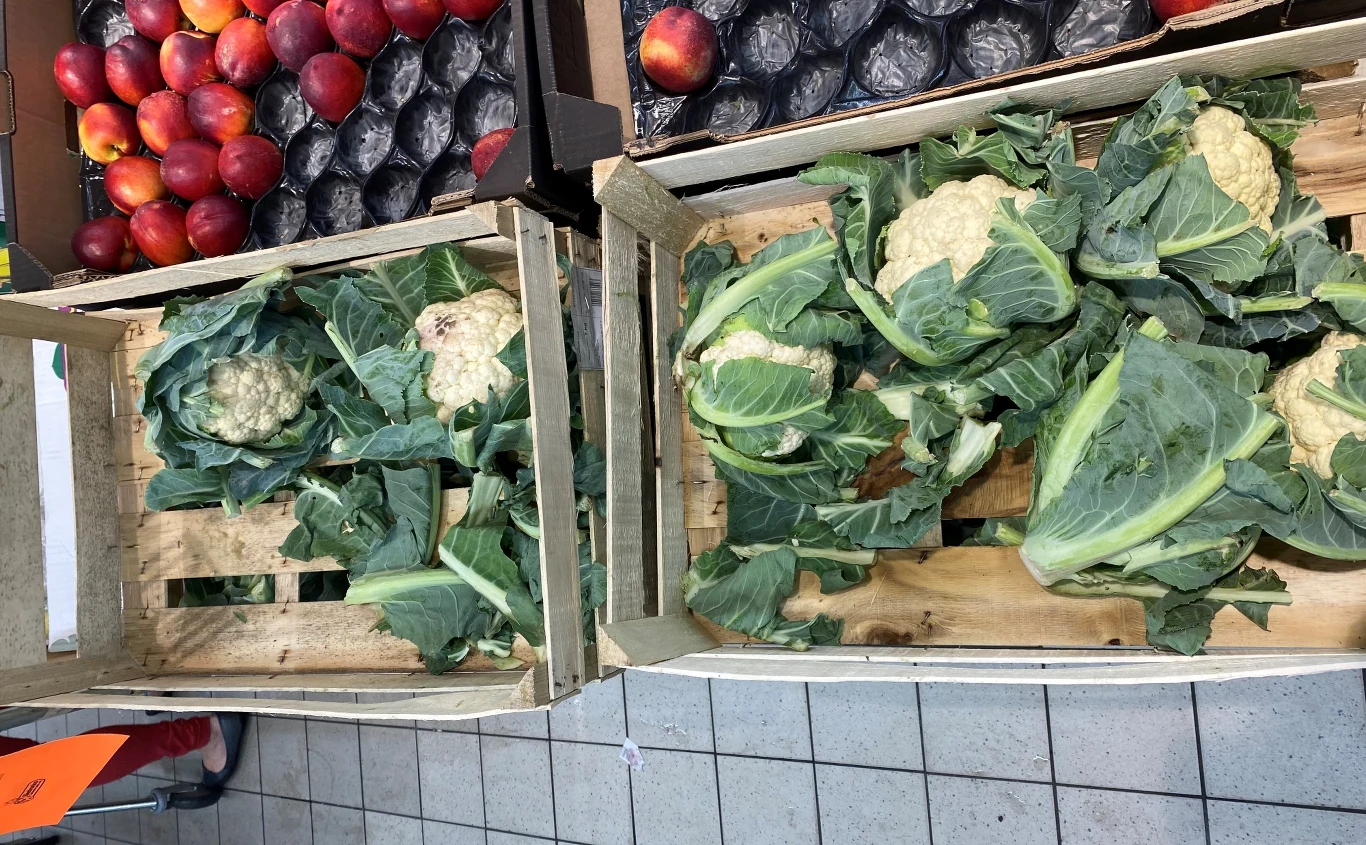 Dwie skrzynki z kalafiorami wystawionymi na szczycie działu warzywnego. Mimo, że warzywo tego dnia było w promocji, od rana pojawiały się oberwane liście.