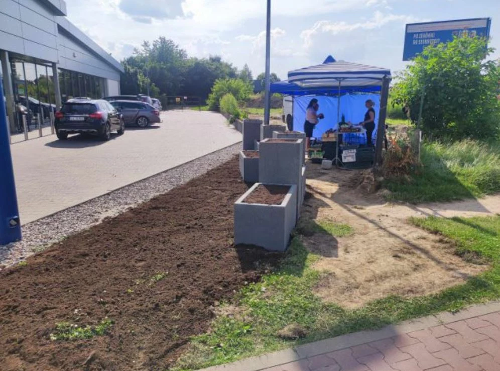 Betonowe donice utrudniają dojście do straganu z warzywami i owocami