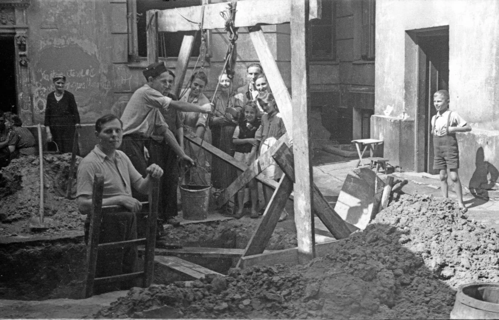 Kopanie przez mieszkańców studni prawdopodobnie na podwórzu kamienicy przy ul. Hożej 9, druga połowa sierpnia 1944 r.