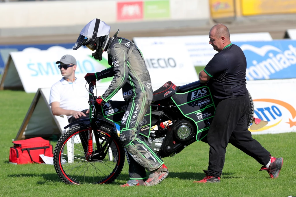 Paweł Trześniewski z tatą Radosławem Trześniewskim niosą zdefektowany motocykl. Paweł Trześniewski z tatą Radosławem Trześniewskim niosą zdefektowany motocykl.
