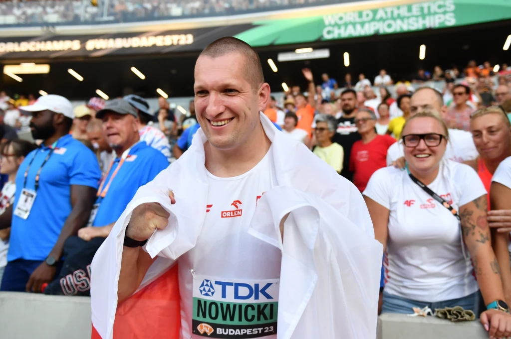 Wojciech Nowicki, a w tle jego trenerka Joanna Fiodorow
