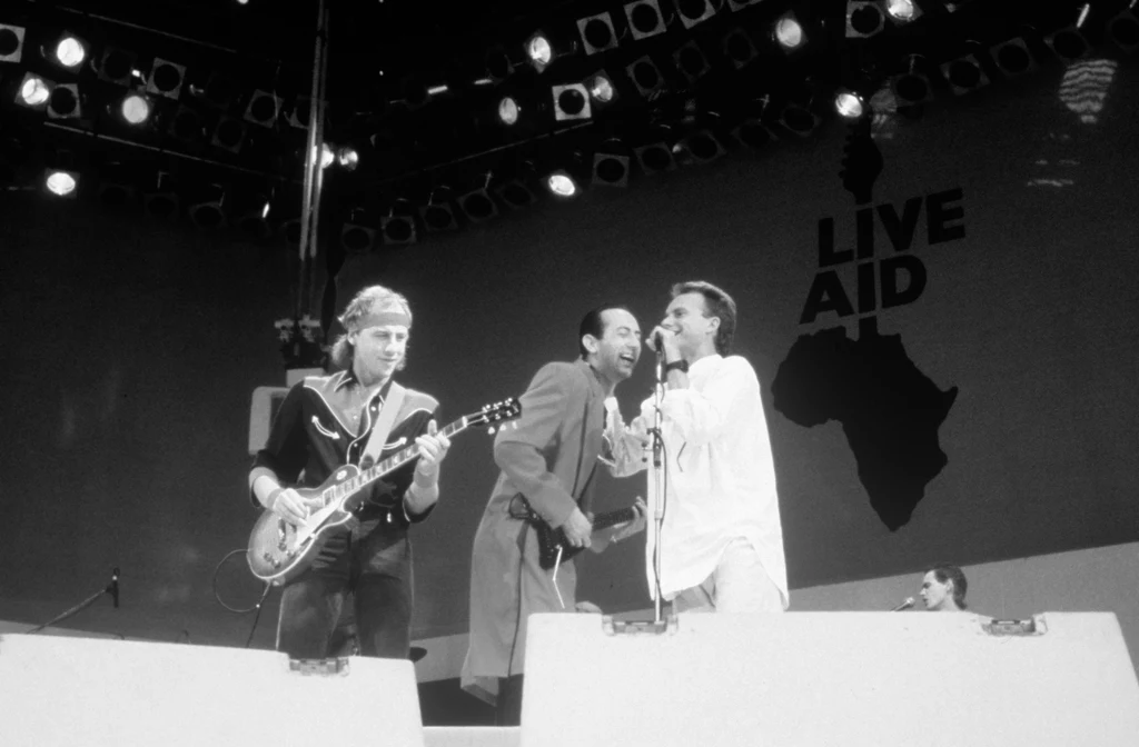 Jack Sonni (w środku) w składzie Dire Straits podczas koncertu Live Aid w Londynie w 1985 r. Z lewej Mark Knopfler, z prawej Sting