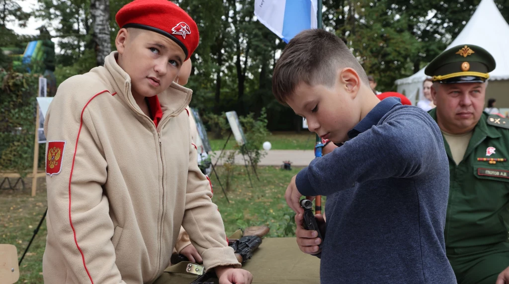 Chłopiec ubrany w mundurek szkolnego klubu patriotycznego podczas imprezy promującej pomoc dla armii rosyjskiej 