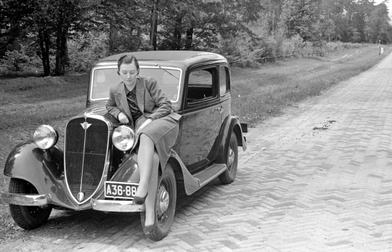 Kobieta na błotniku Polskiego Fiata 508. Widoczna nawierzhcnia drogi wykonana z cegły klinkierowej / fot. Narodowe Archiwum Cyfrowe