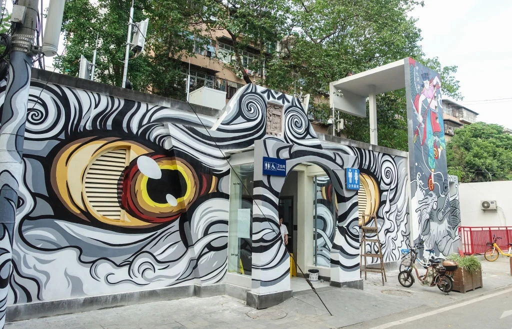 Publiczna toaleta w Chengdu. Budynek ozdobiono graffiti. Zdarza się, że publiczne szalety wyposażane są w wi-fi, bankomaty oraz kamery do rozpoznawania twarzy