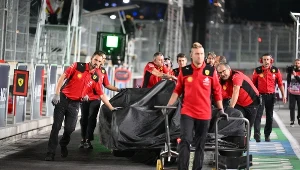 Mechanicy Ferrari, w tle uszkodzony bolid Carlosa Sainza