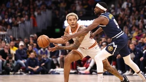 Jeremy Sochan mierzy się z Justinem Holiday'em podczas meczu Denver Nuggets z San Antonio Spurs