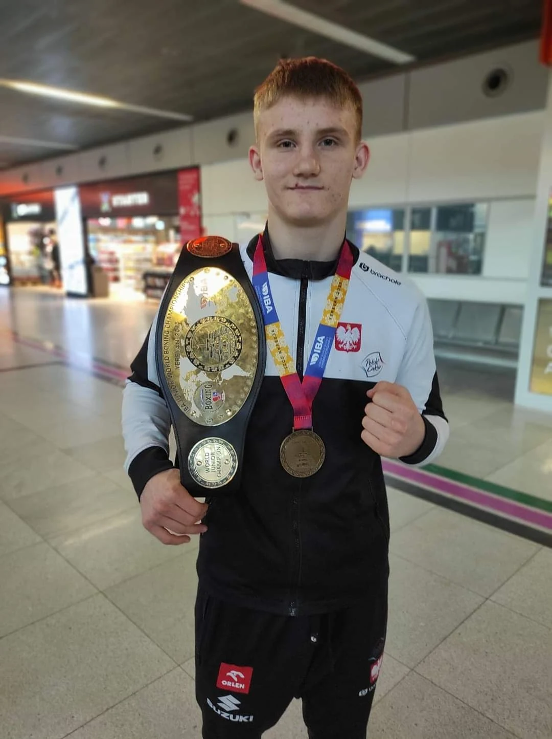 Fabian Urbański ze złotym medalem i pasem mistrza świata