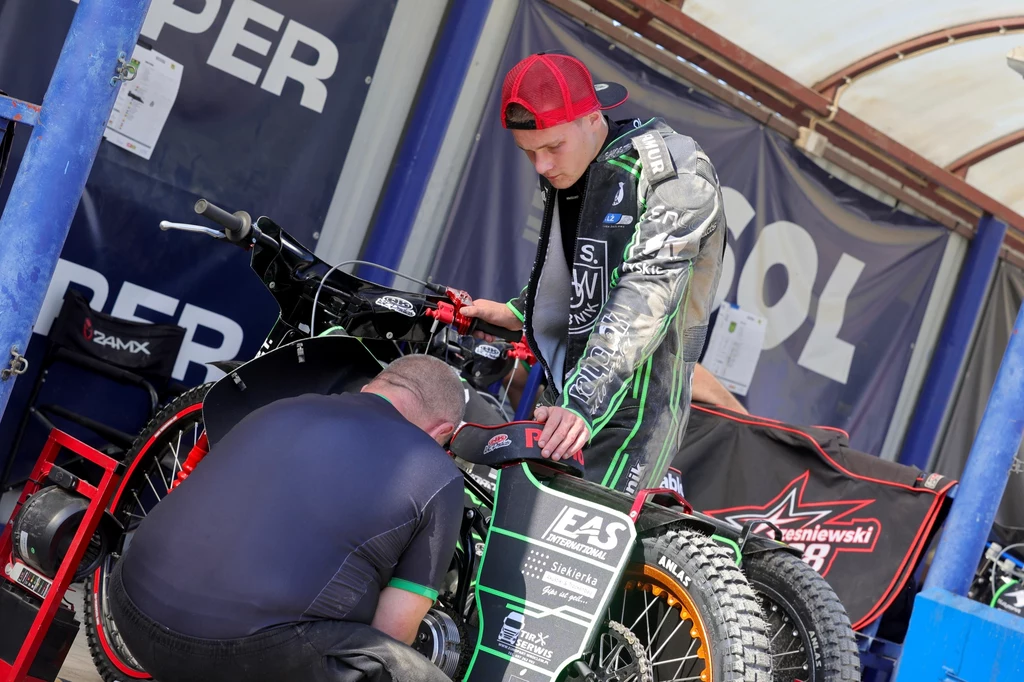 Paweł Trześniewski i mechanik naprawiają motocykl. Paweł Trześniewski i mechanik naprawiają motocykl.