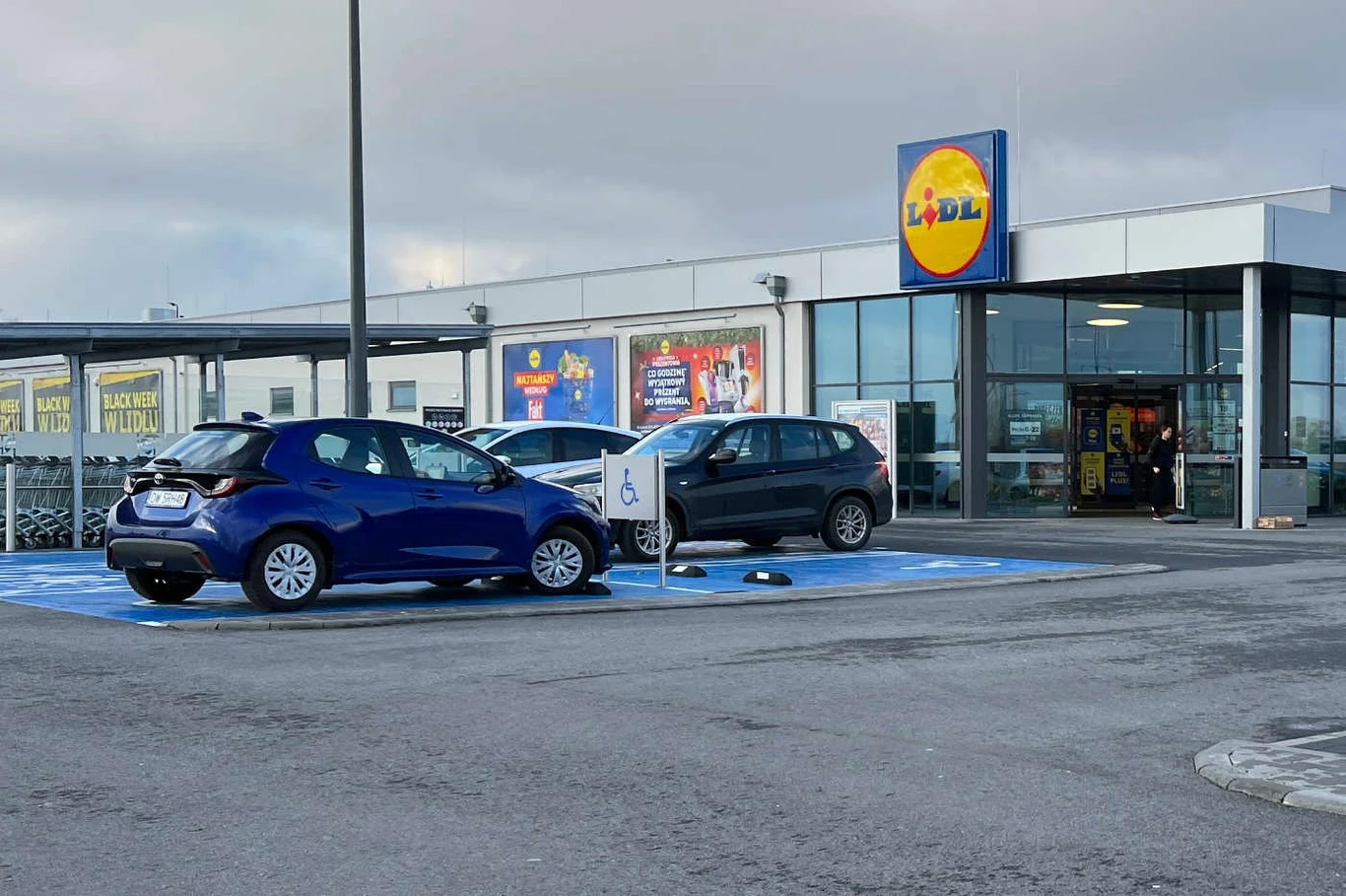 Mandat za parkowanie pod Lidlem - czy trzeba płacić? Decyzja UOKiK Samochody zaparkowane pod sklepem Lidl na parkingu płatnym.