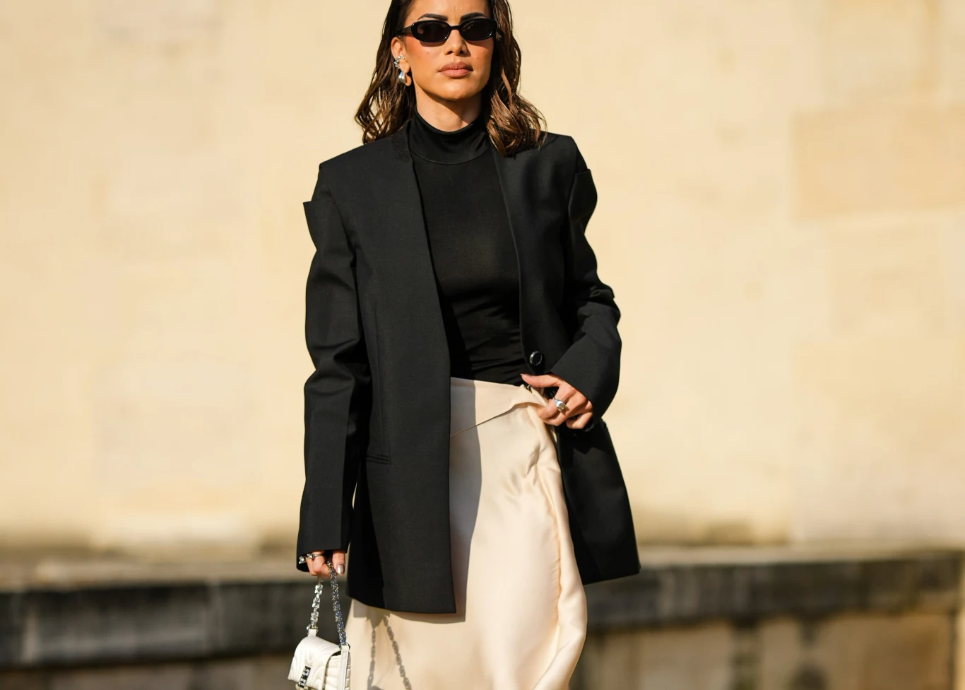 Camila Coelho jasną satynową spódnicę zestawiła z cienkim półgolfem i czarną marynarką