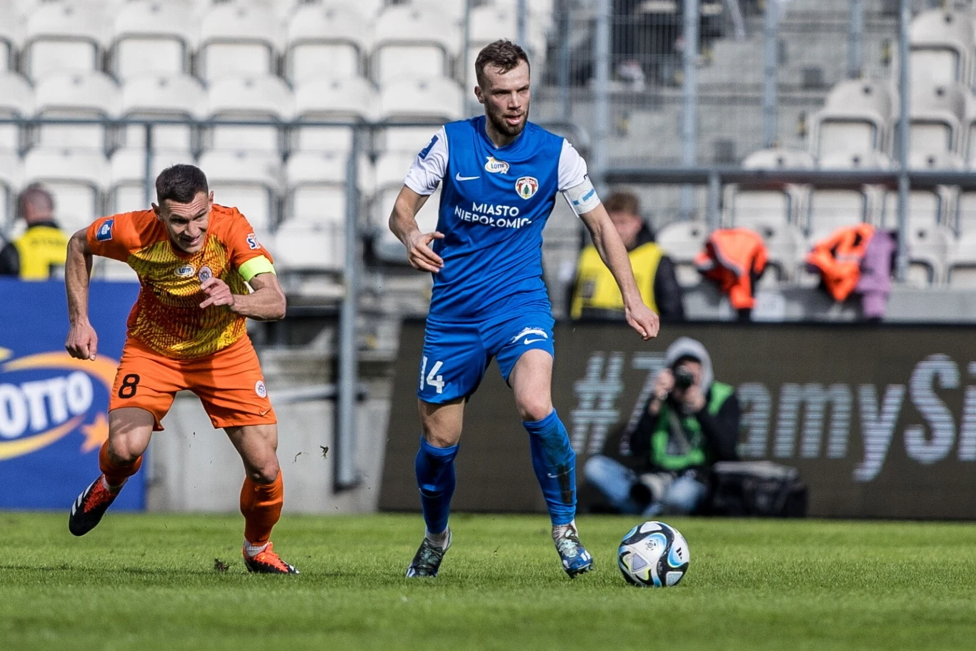 Walka kapitanów. Z piłką Jakub Serafin z Puszczy, goni go Damian Dąbrowski z Zagłębia Walka kapitanów. Z piłką Jakub Serafin z Puszczy, goni go Damian Dąbrowski z Zagłębia