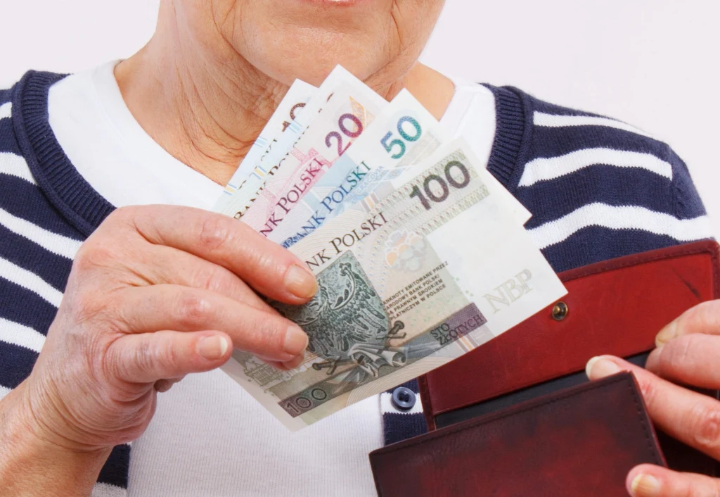 Emerytka trzymająca w ręce polskie banknoty. Polskie złote w gotówce. Emerytka trzymająca w ręce polskie banknoty. Polskie złote w gotówce.