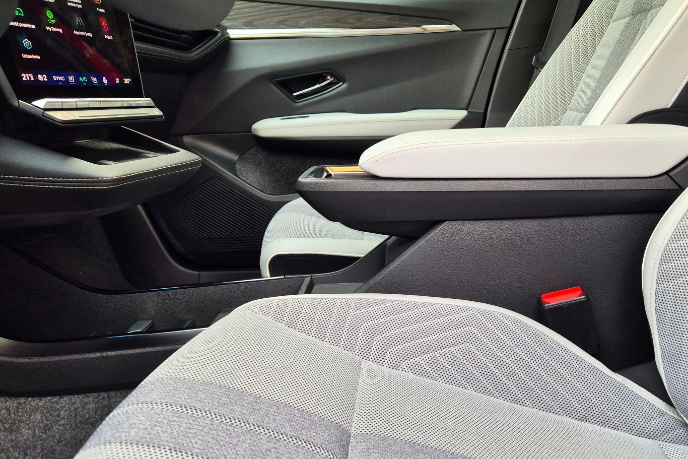 Podłokietnik z przodu ma niewielką regulacją wzdłużną, uchwyty i półki między fotelami umieszczono nieco za nisko