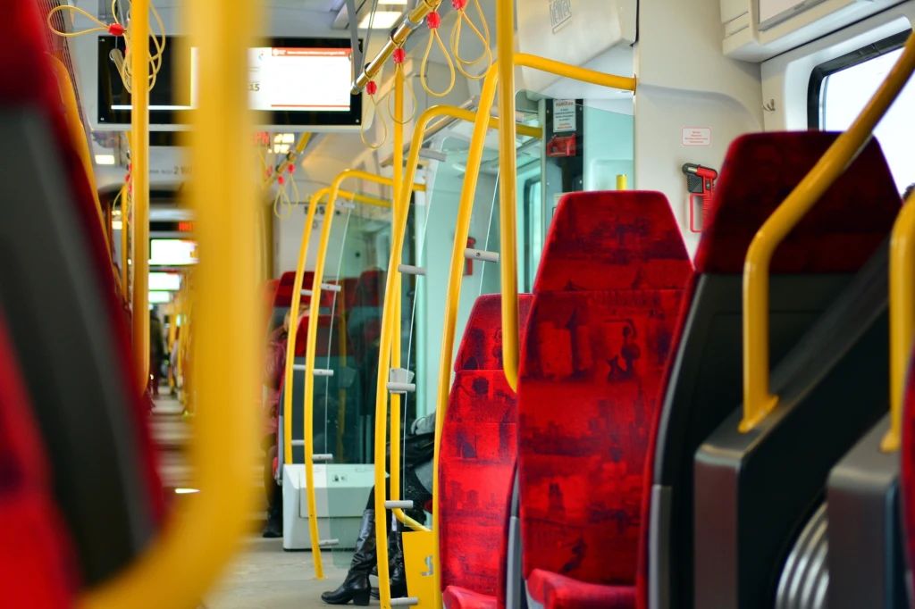 Leżenie w pojazdach ZTM będzie zakazane Komunikacja miejska w Warszawie. Czerwone siedzenia w tramwaju.