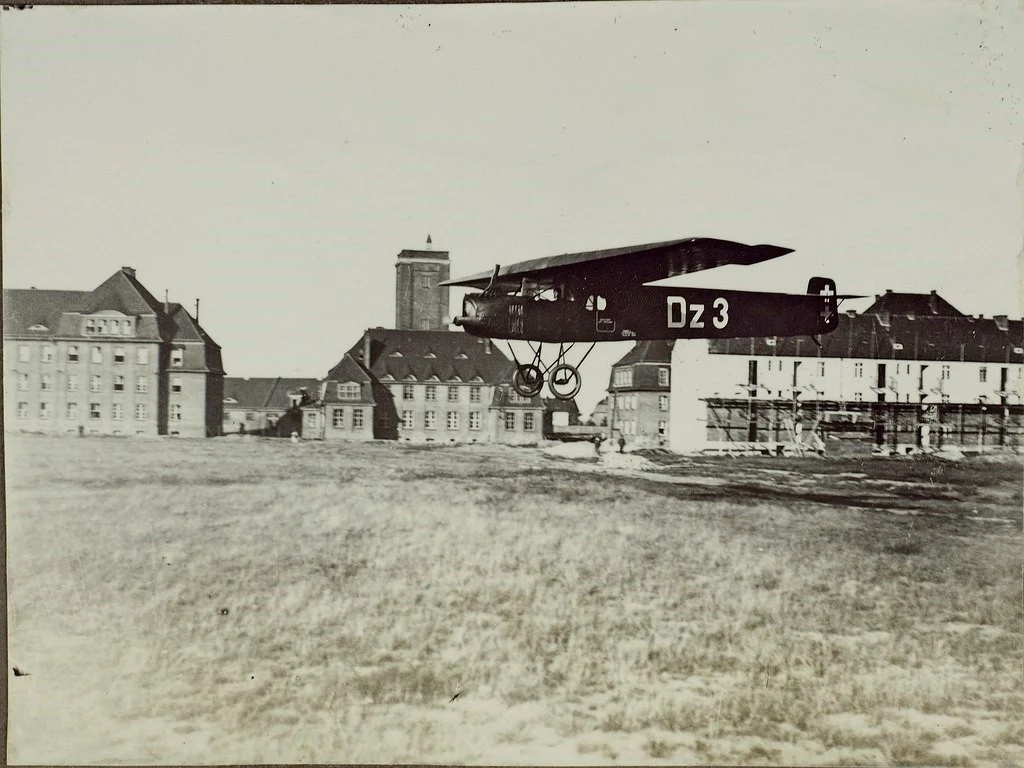 Samolot lądujący na lotnisku Gdańsk-Wrzeszcz w 1922 roku. W tle widoczna wieża Państwowego Obserwatorium przy obecnej alei Legionów