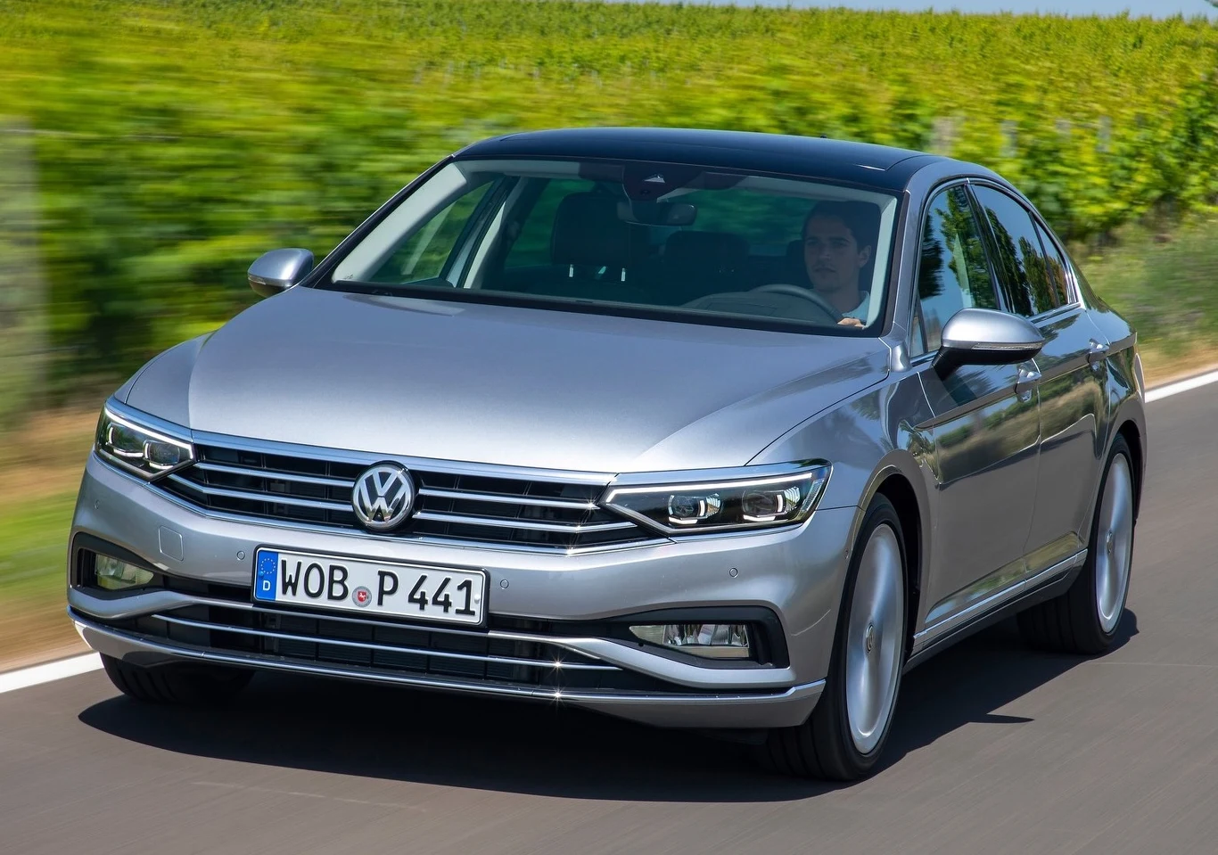 "Żółte anioły"ADAC, czyli mobilni mechanicy assistance, podsumowali 2025 rok. Mamy listę 54 najmniej usterkowych aut używanych Srebrny Volkswagen Passat na wiejskiej drodze, wokół zielone pola i jasne, słoneczne niebo.