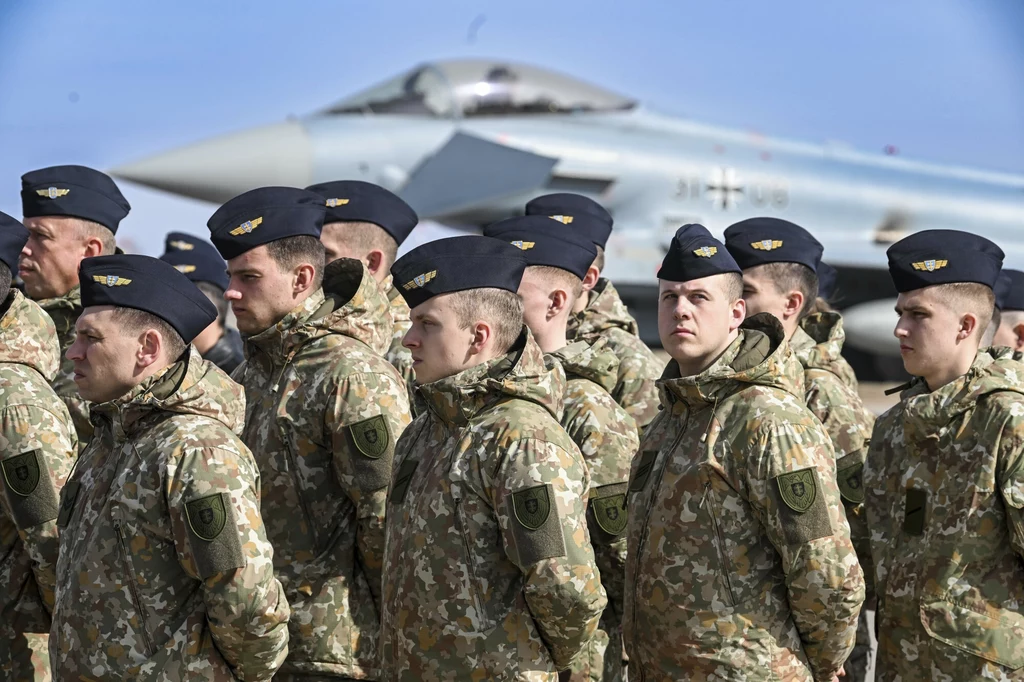 Litewscy żołnierze na tle niemieckiego samolotu bojowego Eurofighter Litewscy żołnierze na tle niemieckiego samolotu bojowego Eurofighter