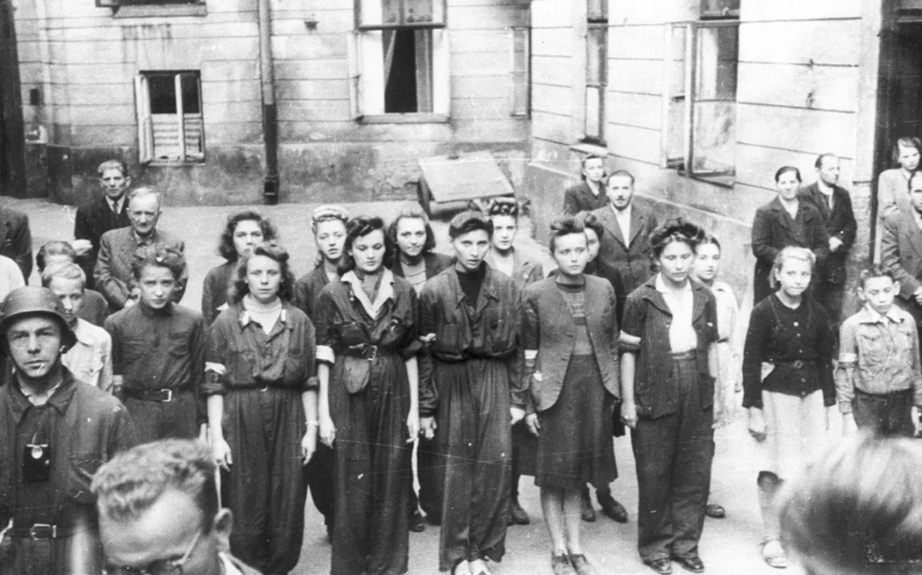 Sanitariuszki i łączniczki z Batalionu „Miłosz” podczas mszy św. odprawianej w Śródmieściu Południowym, sierpień 1944 r. (fot. Wojciech Marczyński „Bogusław”)