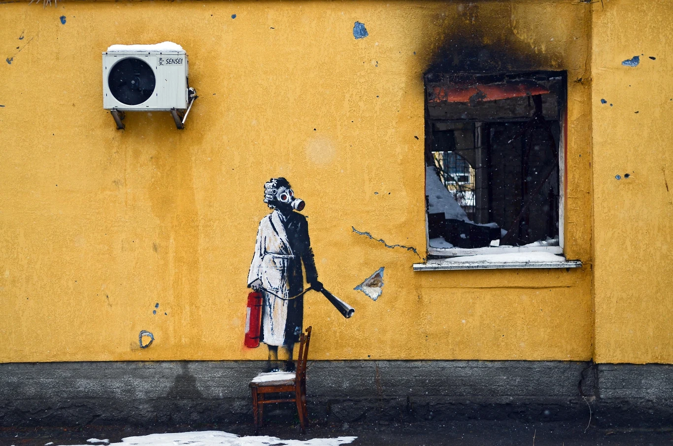 Mural Banksy'ego przedstawia kobietę w masce gazowej stojącą na krześle i trzymającą gaśnicę, Hostomel, obwód kijowski, północna Ukraina.