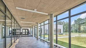 Akustyczne panele Heradesign Superfine Alpha wykorzystane na korytarzach szkolnych charakteryzują się lepszymi, w porównaniu ze standardowymi płytami, właściwościami pochłaniania dźwięku bez konieczności zwiększenia grubości płyty. Foto: Bartosz Makowski